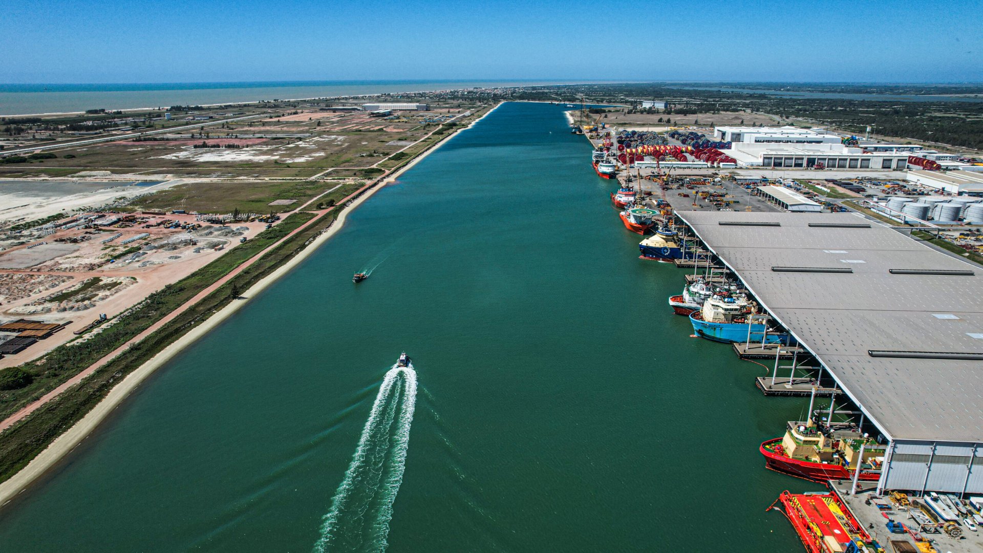 Vista aérea de canal portuário com embarcações de apoio offshore atracadas